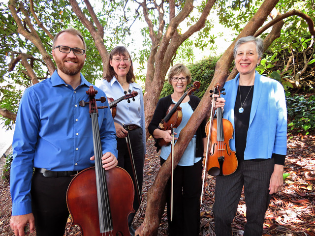 Arcata Bay Quartet standing amongst trees, holding instruments