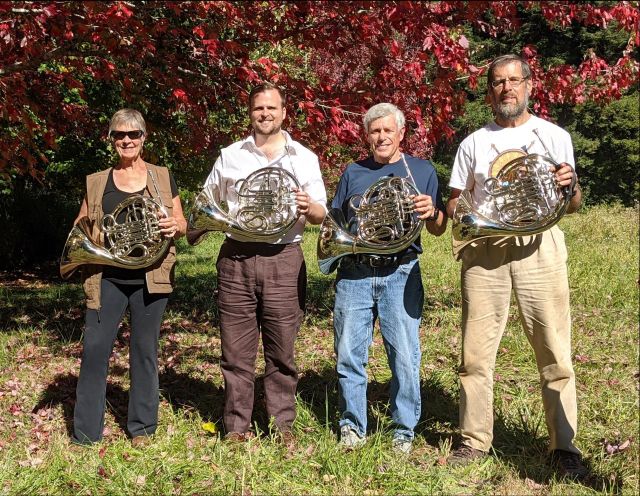 Four Seasons Horn Quartet standing on grass, holding instruments