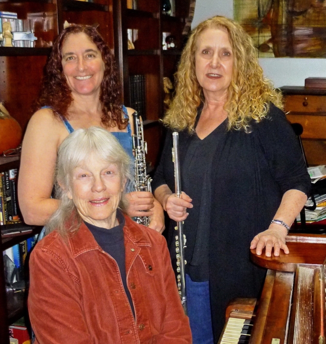 Lyric Trio:: 2 players holding oboe and flute, stand behind 1 seated at piano